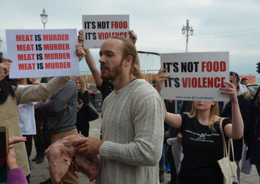 Na protest proti vegánom jedol priamo pred nimi surovú hlavu z prasaťa.