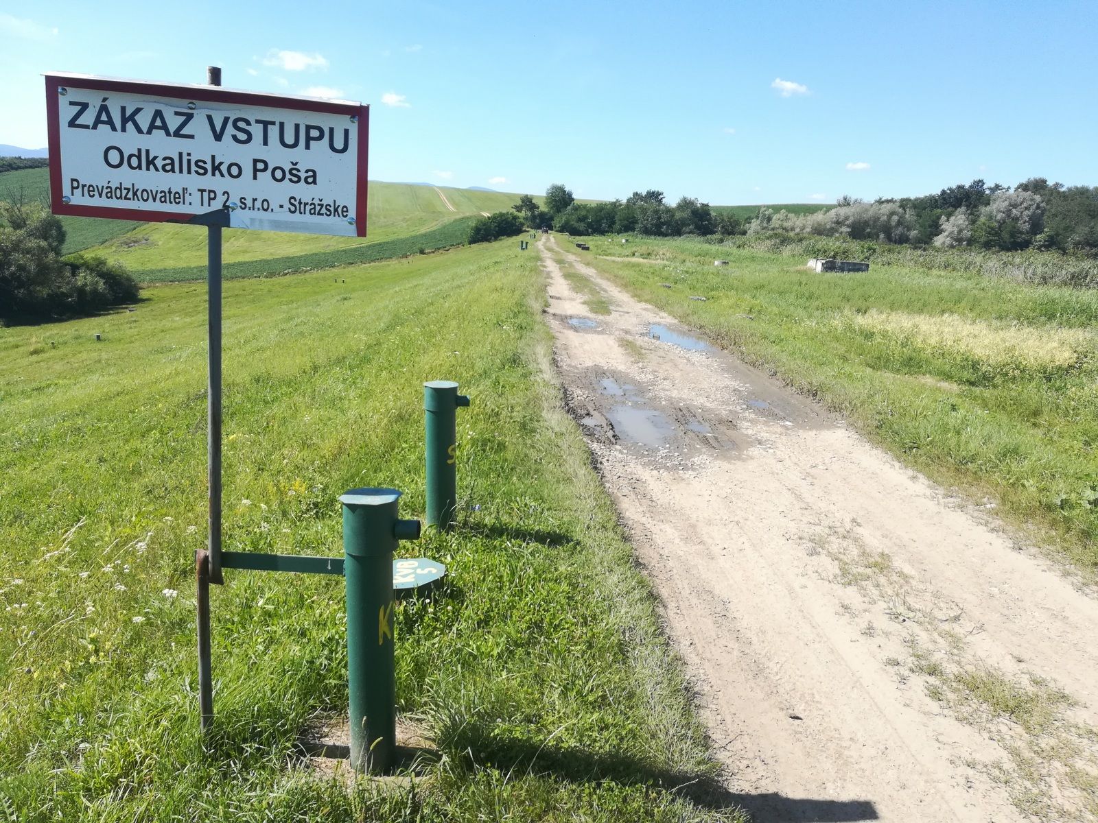 Hrádza odkaliska. Niekoľko metrov odtiaľto unikajú jedy do prameňa Kyjovského potoka.