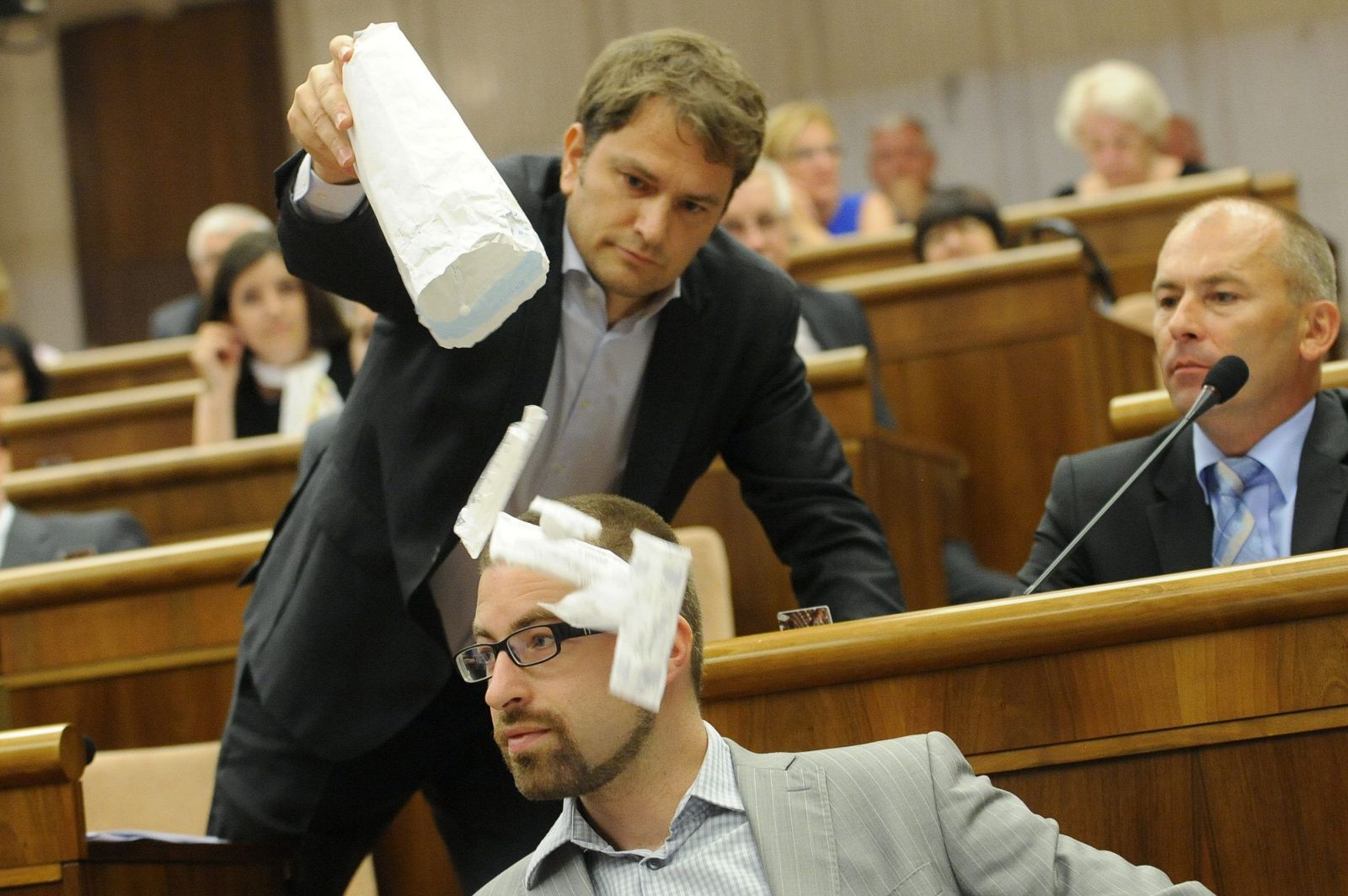 Líder OĽaNO Igor Matovič (hore) obsypáva injekčnými striekačkami poslanca SaS Martina Poliačika počas 7. schôdze Národnej rady SR  11. septembra 2012 v Bratislave.